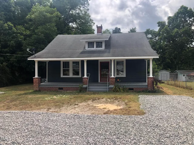 a view of a house with a yard balcony and large tree