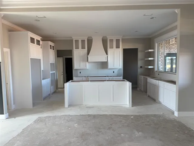 a large kitchen with kitchen island a large counter top stainless steel appliances and cabinets