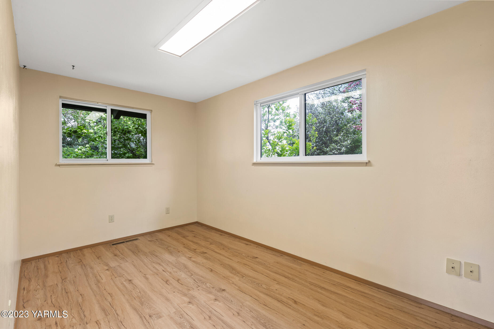 250 Bagley Road Granger, WA 98932 - Photo 11 of 23 an empty room with wooden floor and windows