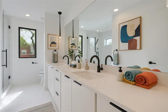 a bathroom with a double vanity sink mirror and shower