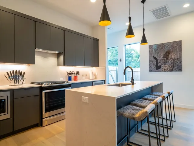 a kitchen with stainless steel appliances a sink a stove and a refrigerator