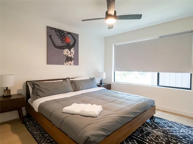 a bedroom with a bed and a painting on the wall