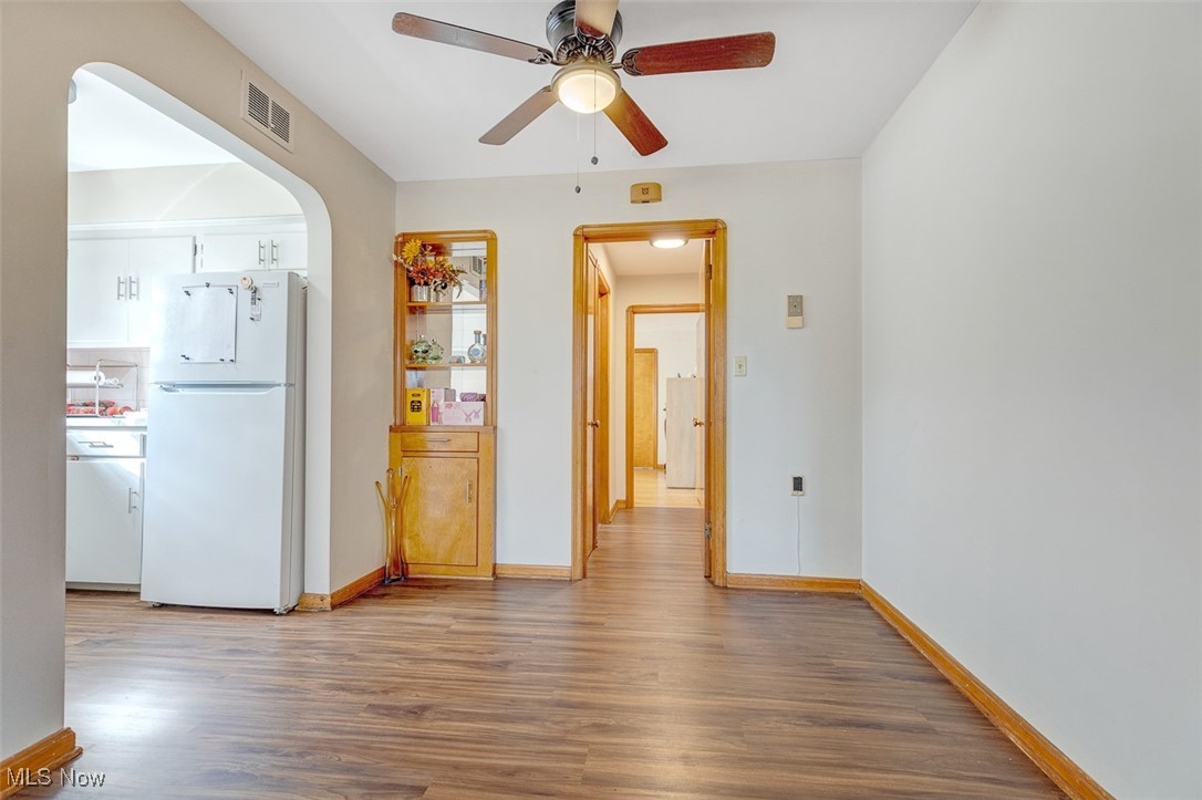 6136 Ridge Road Cleveland, OH 44129 - Photo 22 of 40 Unfurnished dining area with light wood-style floors, arched walkways, and a ceiling fan