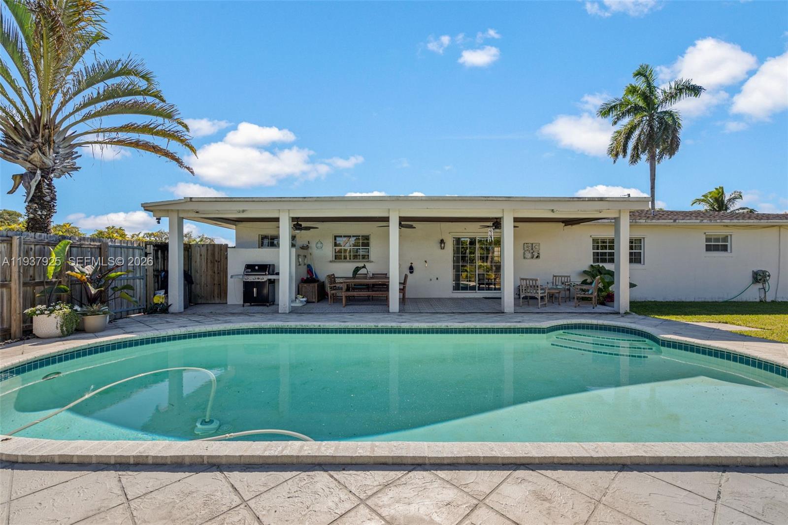 12805 Southwest 193rd Terrace Miami, FL 33177 - Photo 12 of 61 a view of a house with swimming pool having outdoor seating