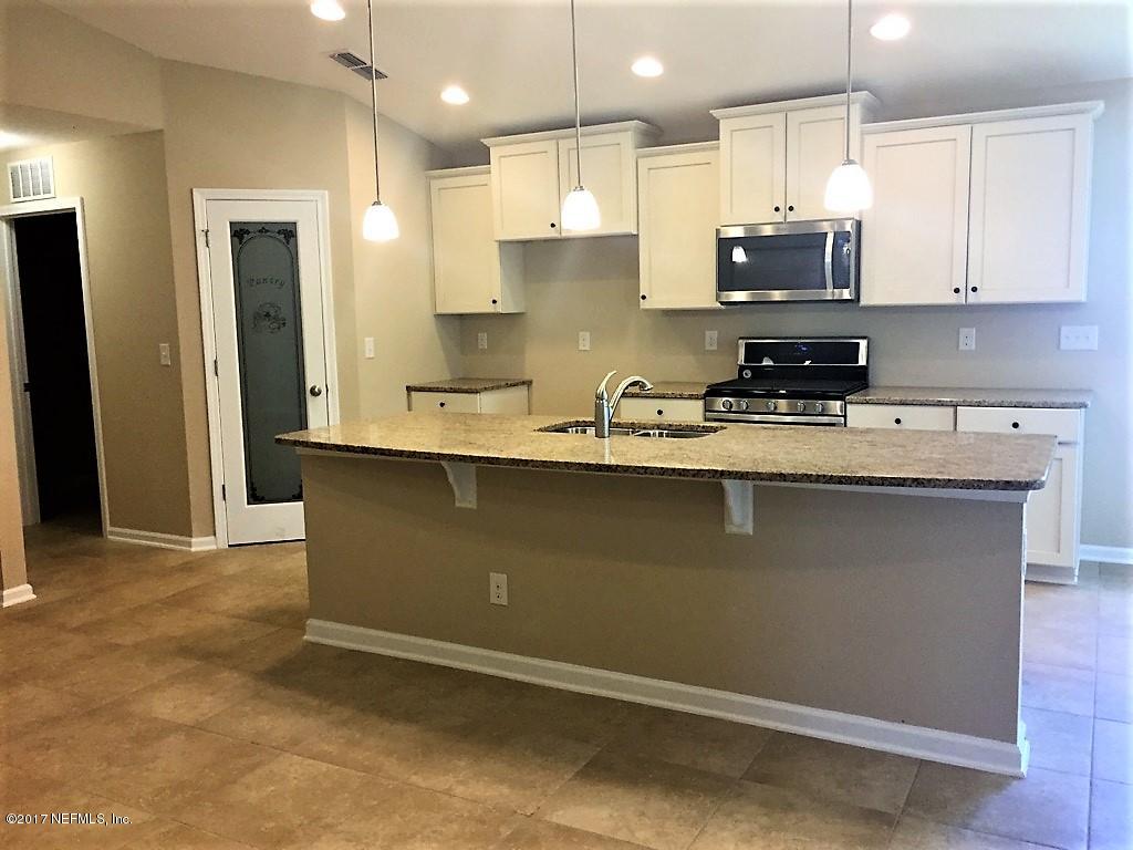 313 Deer Crossing Road St. Augustine, FL 32086 - Photo 2 of 11 a kitchen with stainless steel appliances granite countertop a sink a stove a refrigerator and cabinets