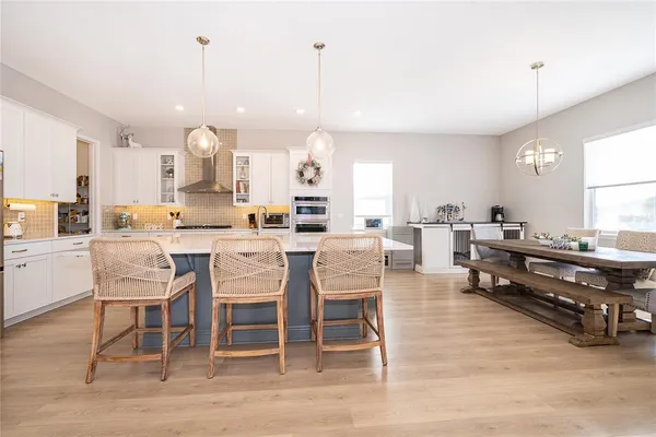 a kitchen with stainless steel appliances kitchen island granite countertop a sink a stove top oven a counter space and cabinets