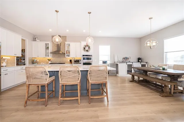 a kitchen with stainless steel appliances kitchen island granite countertop a sink a stove top oven a counter space and cabinets