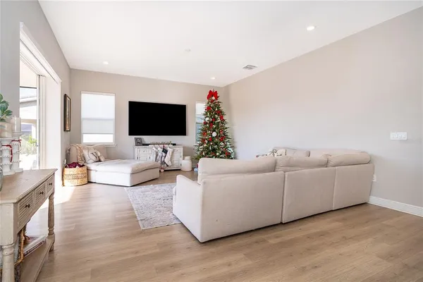a living room with furniture a flat screen tv and a large window