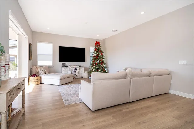 a living room with furniture a flat screen tv and a large window