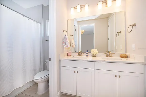 a spacious bathroom with a granite countertop sink and a mirror