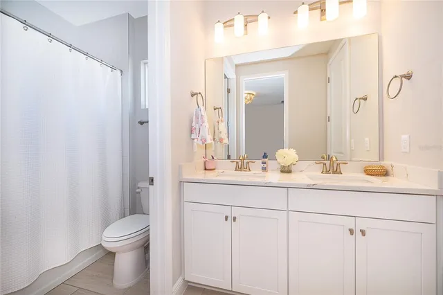 a spacious bathroom with a granite countertop sink and a mirror