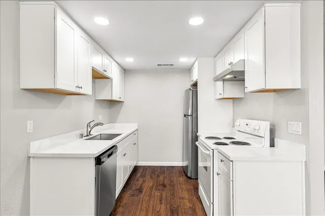 a kitchen with a sink a stove and a refrigerator