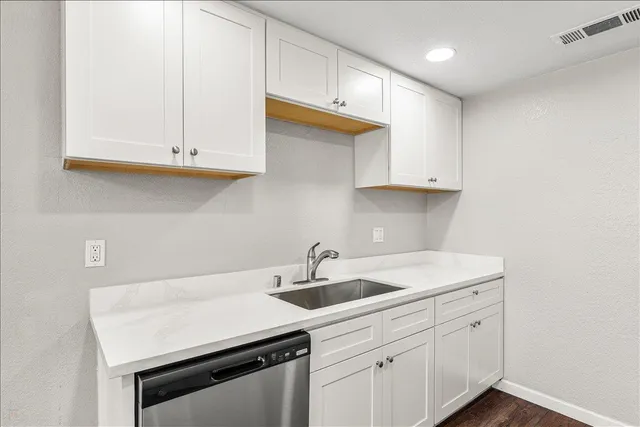 a kitchen with white cabinets and a sink