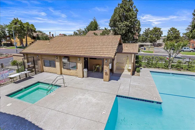 a front view of a house with a yard and potted plants