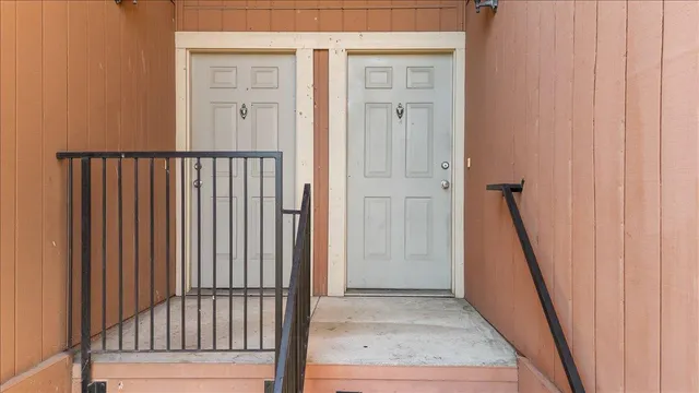 a view of a hallway with wooden floor and stairs