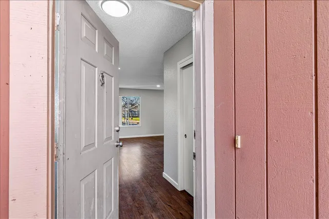 a view of a hallway with wooden floor and entryway