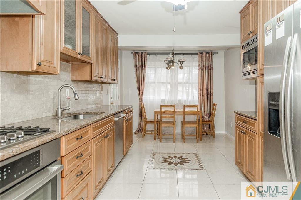 12 Crest Road East Brunswick, NJ 08816 - Photo 4 of 30 a kitchen with stainless steel appliances granite countertop a stove a sink and a refrigerator