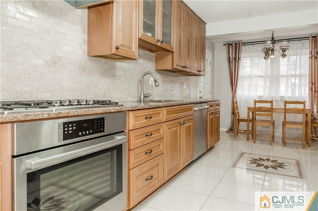 12 Crest Road East Brunswick, NJ 08816 - Photo 9 of 30 a kitchen with stainless steel appliances granite countertop a stove a sink and a microwave