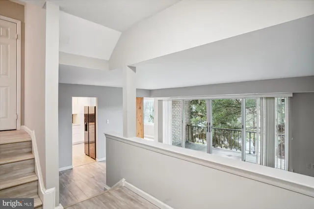 a view of a room with a large window and wooden floor