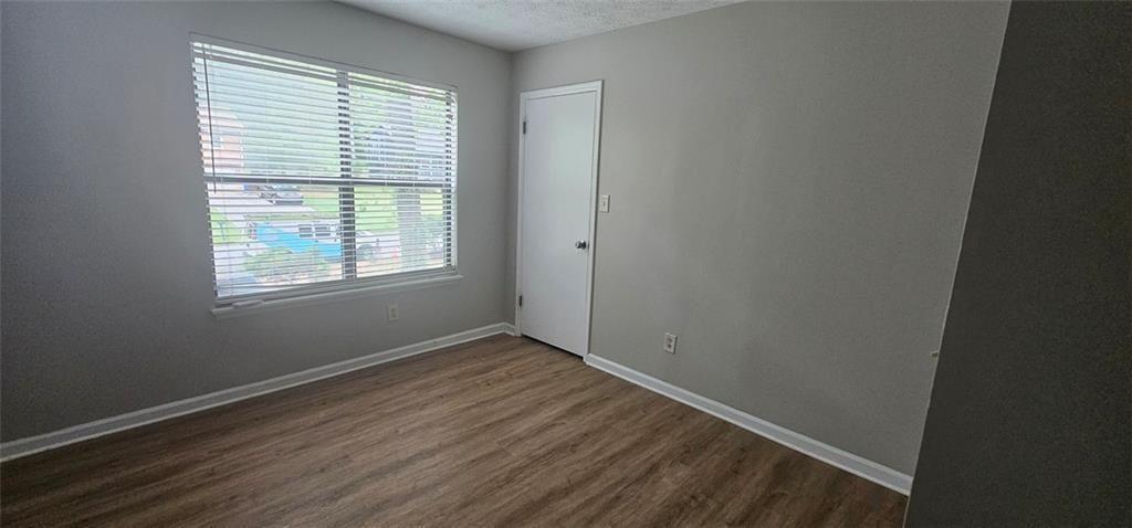 2810 Greenbower Court Atlanta, GA 30349 - Photo 17 of 24 a view of an empty room with wooden floor and a window