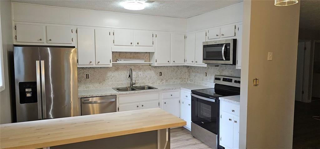 2810 Greenbower Court Atlanta, GA 30349 - Photo 6 of 24 a kitchen with stainless steel appliances a refrigerator stove microwave and sink