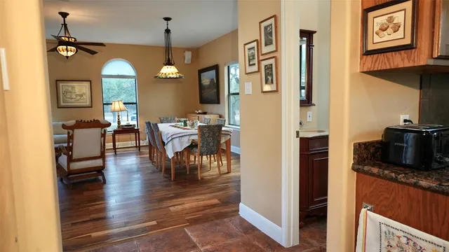 a view of a dining room and livingroom with furniture wooden floor a chandelier