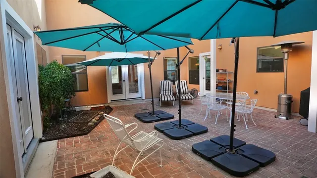 a view of a patio with table and chairs under an umbrella