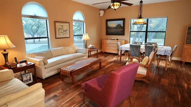 a living room with furniture a flat screen tv and floor to ceiling windows
