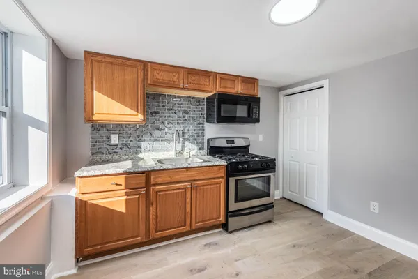 a kitchen with stainless steel appliances a stove microwave and sink
