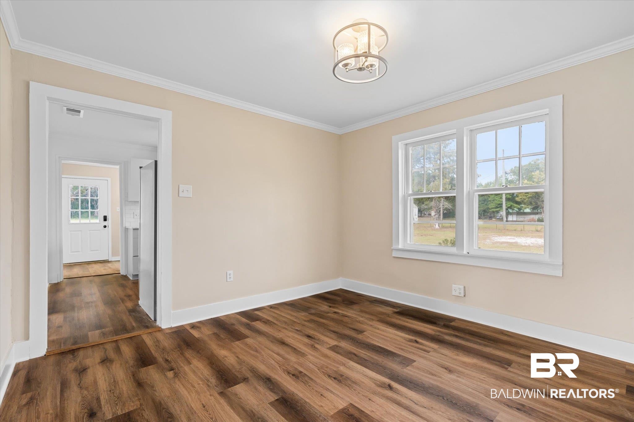 4630 General Road Mobile, AL 36619 - Photo 7 of 33 Empty room featuring dark hardwood / wood-style flooring, crown molding, and an inviting chandelier