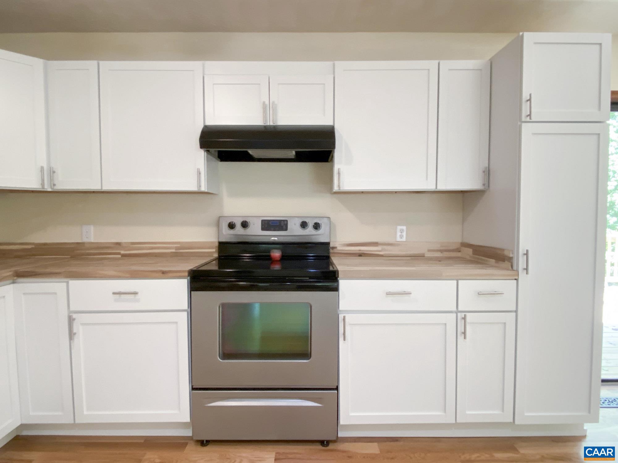 247 Goldenrod Road Ruckersville, VA 22968 - Photo 9 of 35 a kitchen with stainless steel appliances granite countertop a stove a microwave and white cabinets