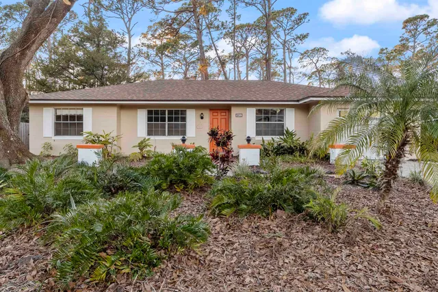 a front view of house with yard and trees around
