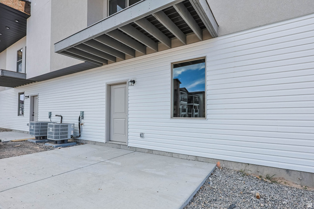 636 West Caroles Way, Unit 7 Tooele, UT 84074 - Photo 31 of 31 Exterior featuring white horizontal siding, a light-colored entry door, and a single-pane window