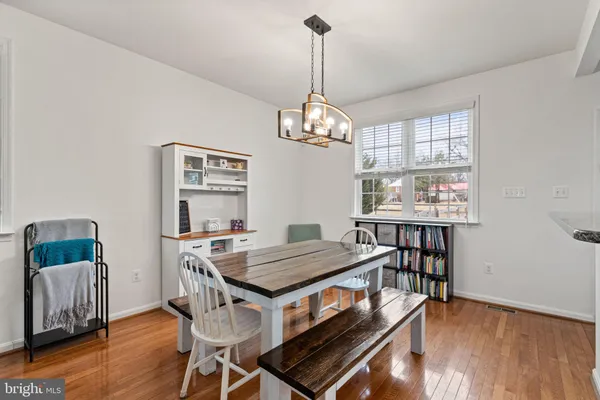 a view of a dining room with furniture wooden floor and chandelier