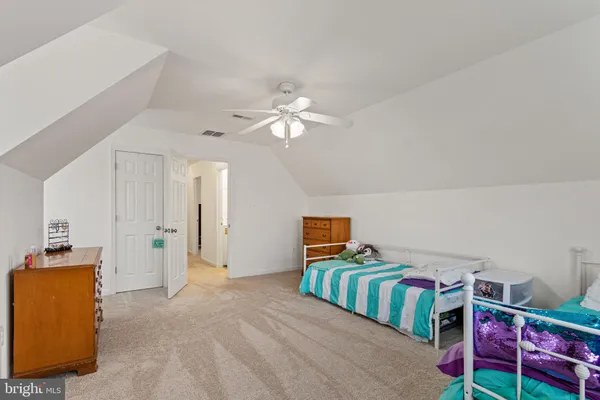 a bedroom with furniture and a chandelier fan