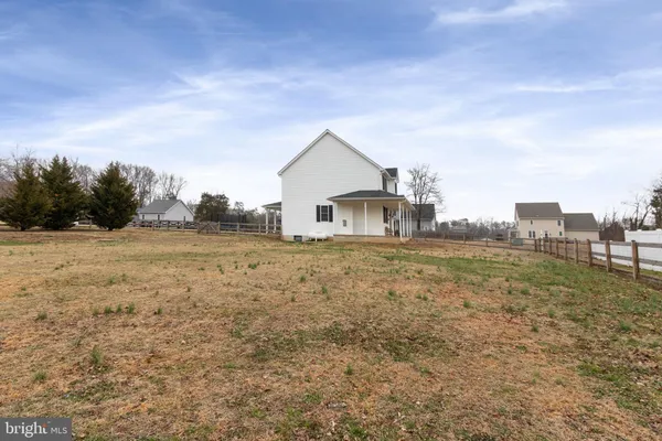 a view of a house with backyard and trees