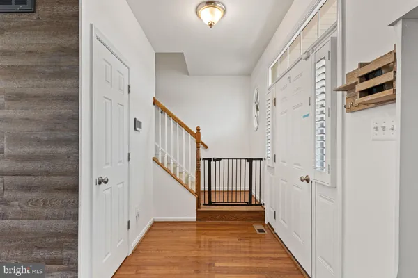 a view of a hallway with wooden floor and entryway