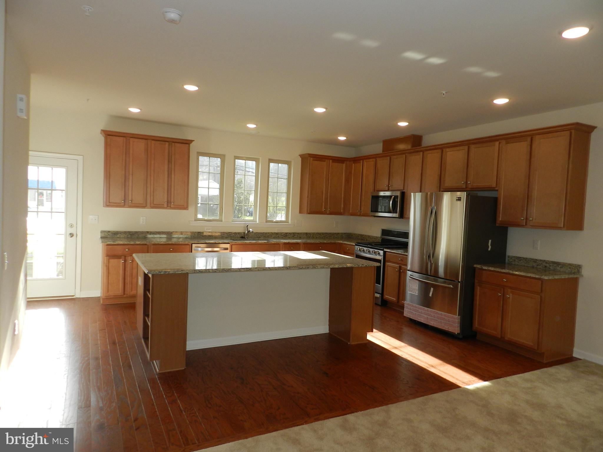27 Eagle Lane Malvern, PA 19355 - Photo 3 of 24 a kitchen with kitchen island granite countertop wooden floors stainless steel appliances a sink and a window