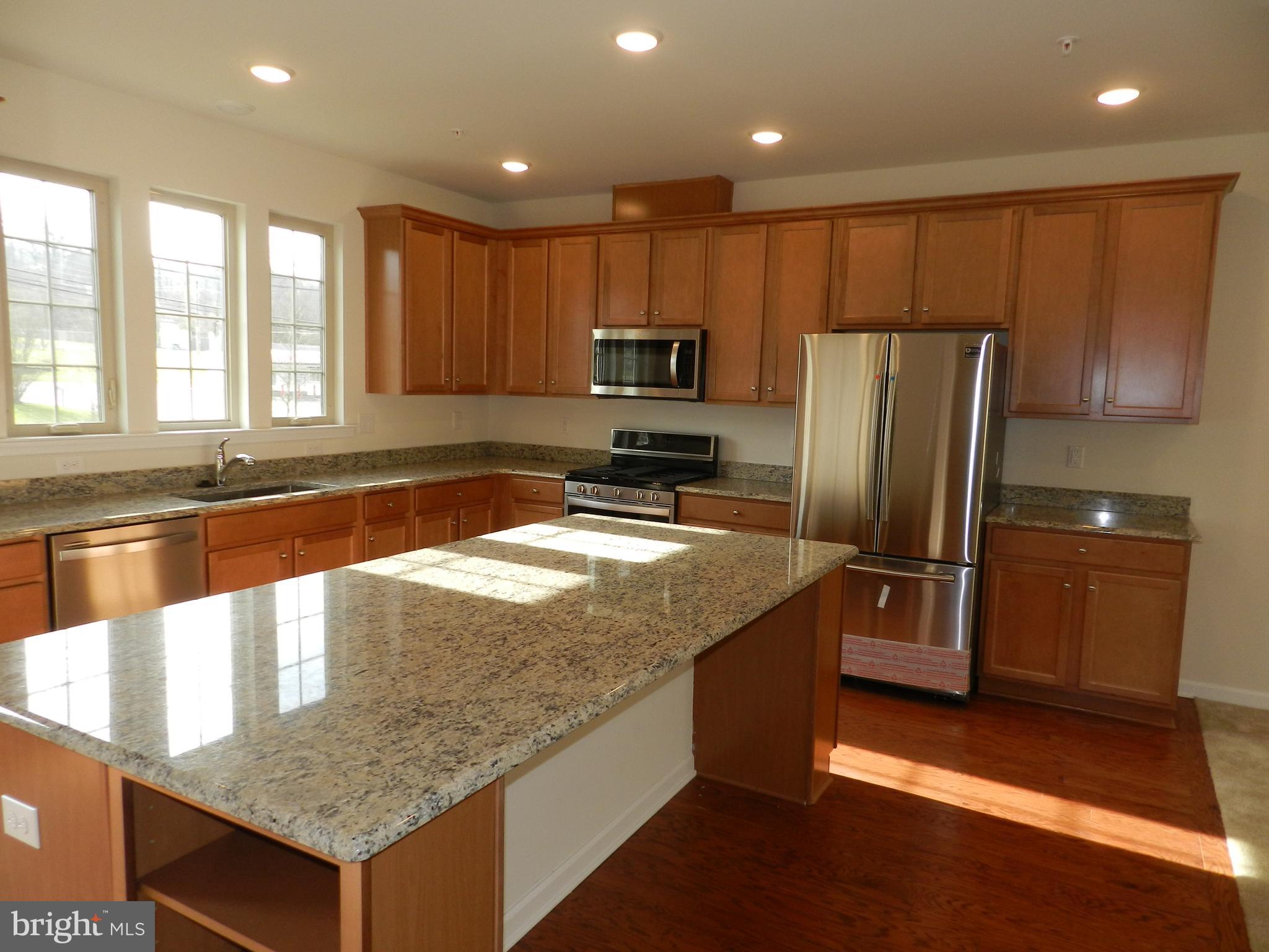 27 Eagle Lane Malvern, PA 19355 - Photo 8 of 24 a kitchen with stainless steel appliances granite countertop a refrigerator a sink a stove a microwave and island