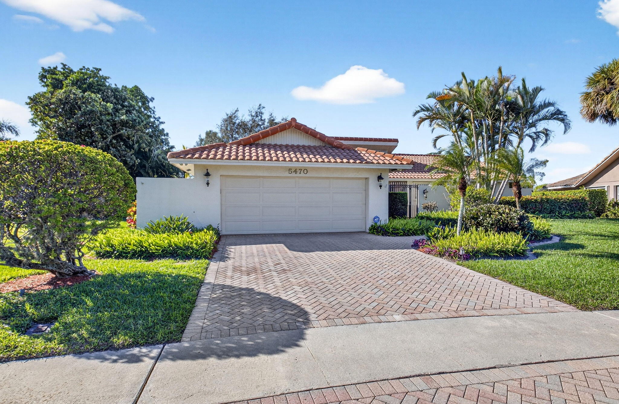 5470 Northwest 3rd Terrace Boca Raton, FL 33487 - Photo 4 of 72 a front view of a house with a garden and pathway