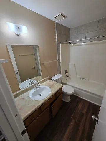 a bathroom with a granite countertop sink toilet a large mirror and shower