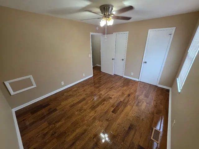 a view of empty room with window and ceiling fan