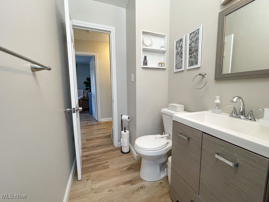 2707 Hearthstone Road Cleveland, OH 44134 - Photo 35 of 49 Half bathroom featuring toilet, vanity, baseboards, and wood finished floors