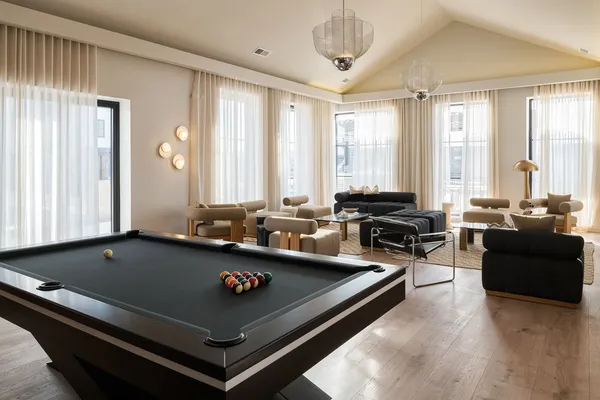 a living room with furniture pool table and a large window