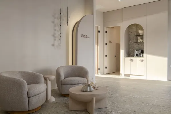 a living room with furniture a mirror and a white walls