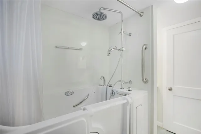 a bathroom with a granite countertop sink a mirror and a shower