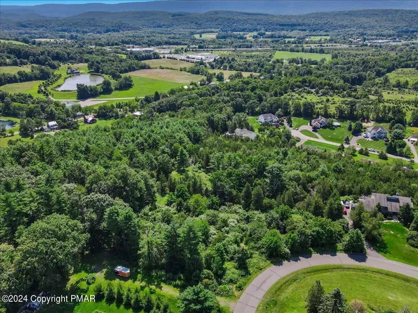 an aerial view of a house with a yard and lake view