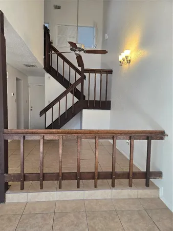 an empty room with wooden floor chandelier fan and windows
