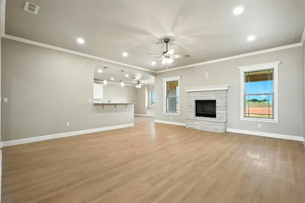an empty room with wooden floor and chandelier fan