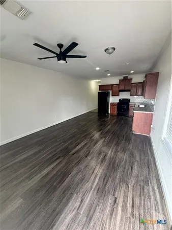 an empty room with wooden floor table and chairs